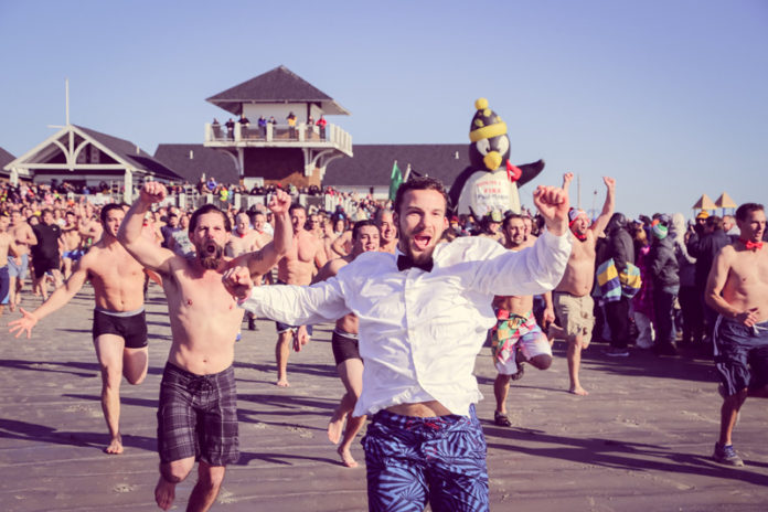 HUNDREDS OF PEOPLE take the plunge for Special Olympics Rhode Island on Jan. 1 at Roger Wheeler State Beach in Narragansett. The annual Penguin Plunge event has raised more than $2 million over three decades. / COURTESY KATIE LARSH