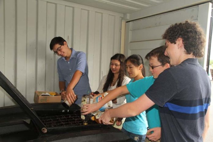 OILED UP: A team of students recycles waste cooking oil at the Westerly Transfer Station.  From left: John Perino, Vanessa Bertsch, Cassandra Lin, Miles Temel and Isaac Kaufman. / COURTESY JASON LIN