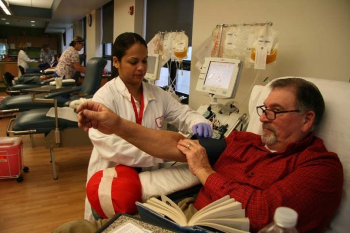 SPEAKING THE LANGUAGE: Nurse Naelia Joa tends to donor Don Groft at the Rhode Island Blood Center. Seventy-eight of the center’s 365 staff members, or 21.4 percent, are Latino. / PBN PHOTO/MICHAEL PERSSON