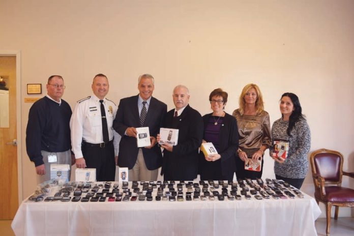 SUPPORTERS OF THE Rhode Island Coalition Against Domestic Violence gather phones to benefit domestic-violence victims. From left: Dan Ormond, law enforcement advocate, Cranston and Johnston police departments; Johnston Police Deputy Chief Daniel Parrillo; Representative Gregory J. Costantino; Mayor Joseph M. Polisena; Deborah DeBare, executive director of the Rhode Island Coalition Against Domestic Violence; Janet Whiteley, administrative assistant, Office of Mayor Joseph M. Polisena; and Jennifer Goldberger, personnel clerk, town of Johnston.