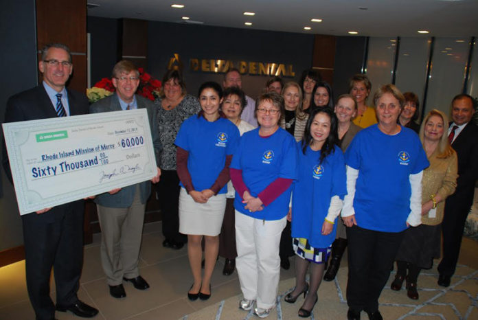 RICHARD A. FRITZ, chief financial officer at Delta Dental of Rhode Island, presents a check to Dr. Jeffrey Dodge, president of the executive board of the Rhode Island Oral Health Foundation, shown here with employee volunteers from Delta Dental of Rhode Island and Mission of Mercy.