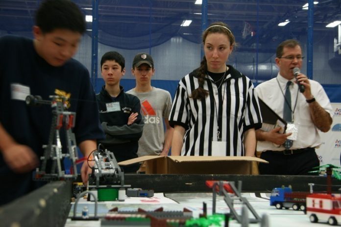 PUTTING THE PIECES TOGETHER: The Rhode Island School of the Future pushes robotics as means to develop both soft skills and those relevant to the engineering field. Above, Julia Smith of Cranston referees at the FIRST Lego League robotics tournament at Roger Williams University on Jan. 11. / PBN PHOTO/MICHAEL PERSSON