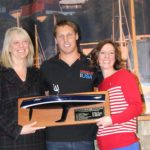 ROME KIRBY, a native Rhode Islander who was a member of the winning America's Cup crew, Oracle Team US, was crowned the John H. Chafee 2014 Boater of the Year by the Rhode Island Marine Trades Association during the Providence Boat Show. Rhode Island Department of Environmental Management Director Janet Coit, left, the 2013 Boater of the Year, presented the award to Kirby. Also pictured is Wendy Mackie, right, CEO of RIMTA. / COURTESY JOE ANDRADE