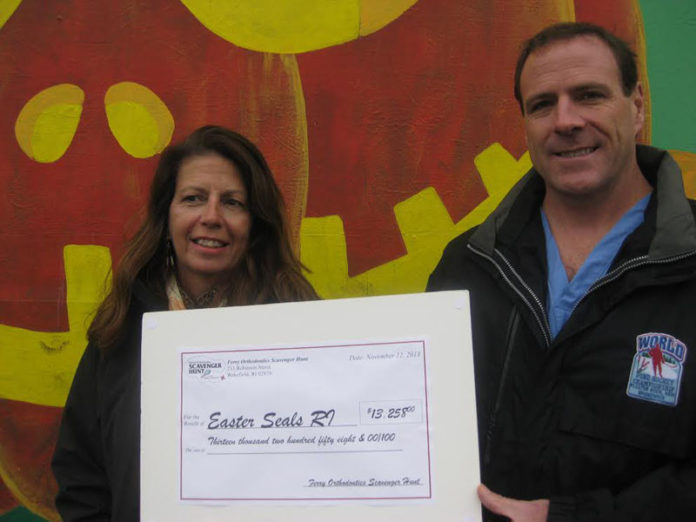 MICHAEL FERRY of Ferry Orthodontics presented a check to Easter Seals Rhode Island Clinical Supervisor Pat O’Leary, in front of the Easter Seals Lights Up October 12th mural at the Dennis Moffit Painting in South Kingstown.