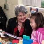 WORKING TOGETHER: Michelle Novello, program coordinator at the Providence Community Library, reads to Marelyn Colon, 5, of Providence. Novello&rsquo;s group&rsquo;s collaboration with two Providence nonprofits helped land a $250,000 grant last year. / PBN PHOTO/MICHAEL SALERNO