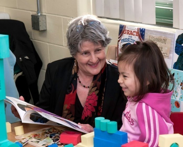 WORKING TOGETHER: Michelle Novello, program coordinator at the Providence Community Library, reads to Marelyn Colon, 5, of Providence. Novello’s group’s collaboration with two Providence nonprofits helped land a $250,000 grant last year. / PBN PHOTO/MICHAEL SALERNO