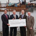 BRISTOL COUNTY SAVINGS BANK is investing $45,000 in the New Bedford Wind Energy Center at the Port of New Bedford. Attending the passing of the ceremonial check are, from left, Matthew Morrissey, managing director of the New Bedford Wind Energy Center, Bristol County Savings Bank President and CEO Patrick J. Murray Jr., New Bedford Mayor Jon F. Mitchell, and Bristol County Savings Bank Senior Vice President for Commercial Lending Pete Selley. / PHOTO COURTESY BOB BARTLETT