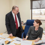 ALL HATS FIT WELL: Kevin Barry, director of finance for the Quonset Development Corporation, has duties far beyond making the numbers work, and he leans on his staff, including Norine Courtemache, an accountant at the quasi-governmental agency. / PBN PHOTO/TRACY JENKINS