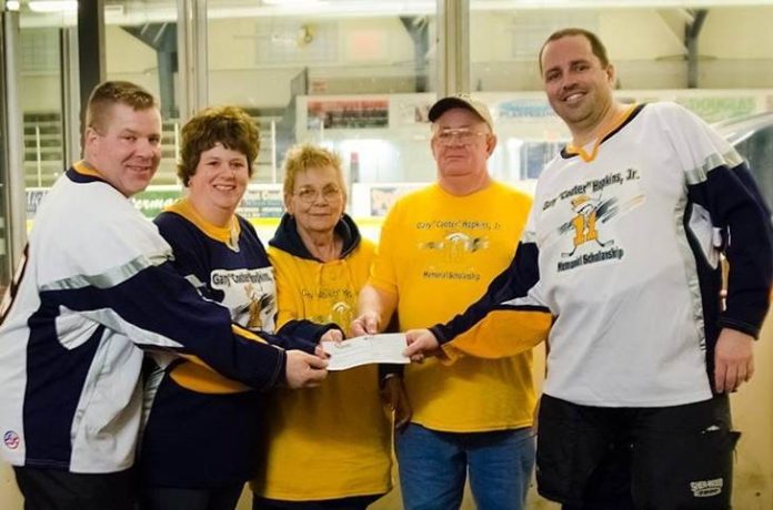 THE HOPKINS family accepts a contribution from Mark Palmer of Granite Telecommunications on March 29 at the June Rockwell Levy Arena in Burrillville. / COURTESY GRANITE TELECOMMUNICATIONS LLC