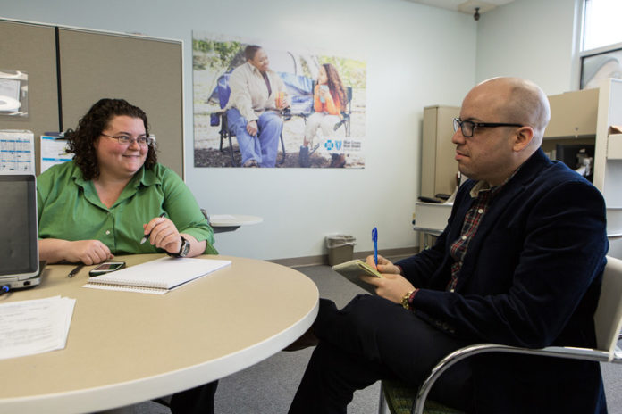 STRENGTH IN NUMBERS: Blue Cross & Blue Shield of Rhode Island sales and customer-services counselors Rosa Tysor and Rafael Rodriguez speak in the company’s new Warwick retail store. The location drew 527 visitors in January and 377 in February. / PBN PHOTO/RUPERT WHITELEY