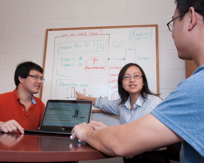 STAR SYSTEM: URI professor Yan Lindsay Sun, center, has developed a prototype software to identify suspicious online reviews. At left in photo is Yihai Zhu and at right Yongbo Zeng, both URI Ph.D. candidates. / PBN PHOTO/MICHAEL SALERNO