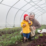 A SEED GROWS: Northeast Organic Farming Association of Rhode Island President Michael Roberts also co-owns Roots Farm in Tiverton with his wife, Kelli. He is pictured above with his son, Ronan. / PBN PHOTO/TRACY JENKINS