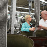 STITCHING TOGETHER A NEW STORY: Hope Global President and CEO Cheryl Merchant, left, has led the transformation of the company into a global supplier of engineered textile solutions. Here she speaks with Robert Ewing, supervisor of the weaving division at the company&rsquo;s Cumberland manufacturing facility. / PBN PHOTO/RUPERT WHITELEY