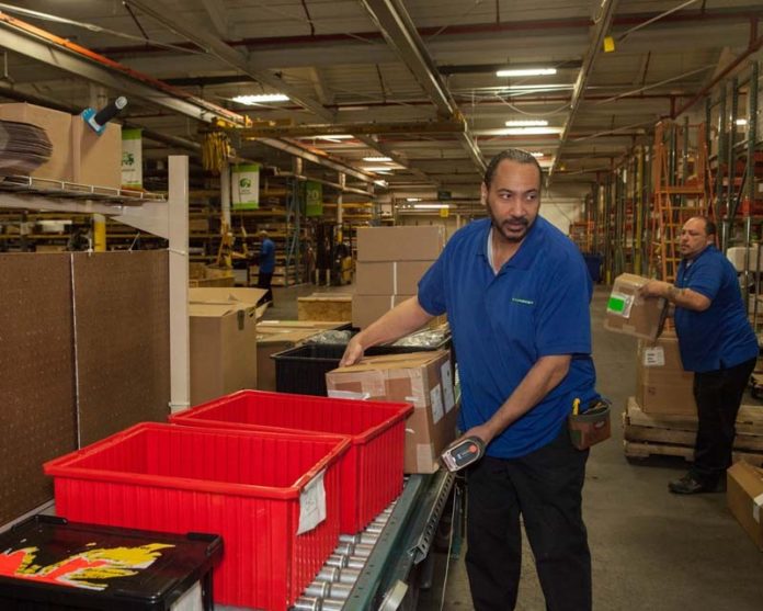 PACK, STACK AND GO: Banneker Industries employee Nick Vierira doing what the company does best at its North Smithfield warehouse: handling logistics, including packing and shipping, for third parties. / PBN PHOTO/TRACY JENKINS
