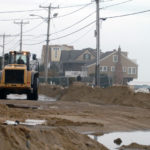 A NEW REPORT issued by the White House Tuesday emphasized the potential impact of climate change, including an increased risk from hurricanes linked to higher sea levels. Above, a machine clears sand off Atlantic Ave. in Misquamicut in the aftermath of Hurricane Sandy in 2012. / PBN FILE PHOTO/BRIAN MCDONALD