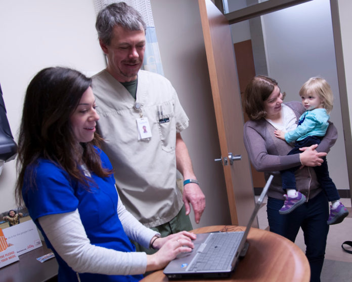 AMANDA ST. GEORGE, left, shadows nurse Todd Kirschhofer at Thundermist Health Center in West Warwick as part of the Passport to Practice program, designed to give unemployed or underemployed nurses experience and help finding a job. Also pictured are Valerie Furr and her mother, Karen Izzo. / PBN FILE PHOTO/MICHAEL SALERNO