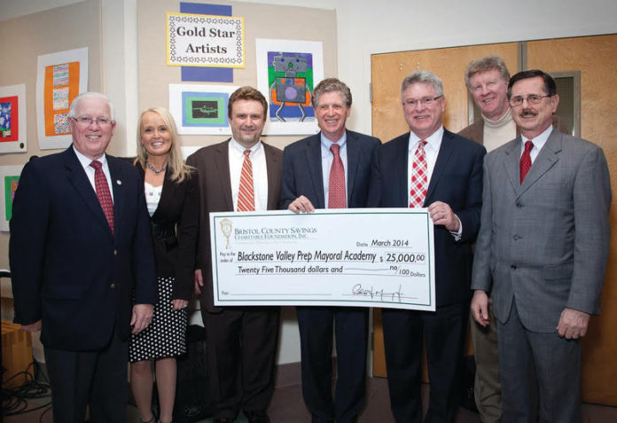 REPRESENTATIVES FROM Bristol County Savings Bank and its foundation present a $25,000 check to Blackstone Valley Prep Mayoral Academy, from left: Dennis Kelly, chairman, BCSCF; Michele Roberts, executive vice president, BCSB and clerk, BCSCF; Jeremy Chiappetta, executive director, Blackstone Valley Prep; Daniel McKee, Cumberland mayor and board chairman, Blackstone Valley Prep; Patrick Murray, president and CEO, BCSB and president, BCSCF; Dan Sullivan, president, Collette and board member, BCSCF Pawtucket Advisory Board; and  Ken Riley, AVP, BCSB and board member, BCSCF Pawtucket Advisory Board.