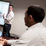 Tech Collective fellowship a path to employment COLLECTIVE THOUGHT: Christopher Guilmette, left, a 2012 Tech Collective Graduate Fellowship Program alum and Atrion SMB employee, with dedicated-service engineer Anel Perez. / PBN PHOTO/MICHAEL SALERNO