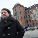 Expiring tax deals pose challenges GOING UP? Robert Houllahan, a Providence filmmaker, stands in front of the Monohasset Mill, where he owns a condominium. Houllahan estimates his taxes will go up from approximately $500 per year to as much as $4,000 per year without the stabilization. / PBN PHOTO/FRANK MULLIN