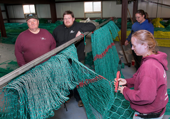 Unpredictable weather, changing fish populations and federal regulation continue to challenge the region’s commercial-fishing industry. But the business of supplying that industry remains strong for family-owned Reidar’s Trawl Gear and Marine Supply, which expanded to a 21,000-square-foot New Bedford building last July. Above, owner Reidar Bendiksen, left, and son Tor Bendiksen, chief operating officer; with employees Meghan Lapp, front, and Sarah Fortin. The women are building a groundfish net. / PBN PHOTO/MICHAEL SALERNO