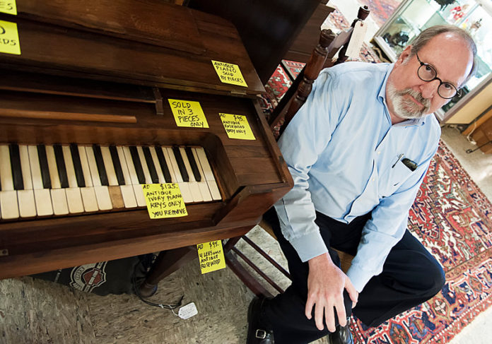 INSTRUMENTAL ROLE: Scott Davis, owner of the Rhode Island Antiques Mall, with a piano with ivory keys. New federal regulations scheduled to go into effect will ban the sale of anything with ivory less than 100 years old to protect endangered elephants. / PBN PHOTO/MICHAEL SALERNO