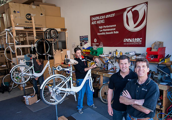 Bristol’s Dynamic Bicycles Inc. sees opportunity in the growing popularity of public and private bike-share networks. The company makes shaft drive systems that propel bicycles without a chain, potentially a major advantage for riders, such as tourists, not dressed in clothes designed for cycling. “It is an exploding market and one that benefits the most from chainless technology,” said company founder Patrick Perugini. Above, from left, Dynamic employees Justin Plamondon and Jaime Raposa, with owners Devin Kelly and Perugini. / PBN PHOTO/MICHAEL SALERNO