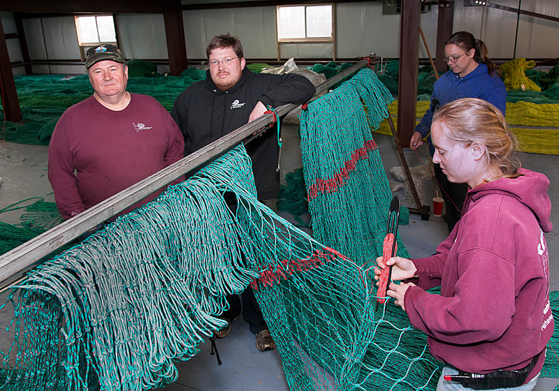 SUPPLY AND DEMAND: Reidar’s Trawl Gear and Marine Supply expanded to a 21,000-square-foot New Bedford building last July. Above, owner Reidar Bendiksen, left, and son Tor Bendiksen, chief operating officer, with employees Meghan Lapp, front, and Sarah Fortin. / PBN FILE PHOTO/MICHAEL SALERNO