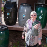 COLLECTIVE THOUGHT: Beverly O&rsquo;Keefe, owner of Rhode Island Water Lady, a small business that sells rain barrels, stands next to one she has installed at home. / PBN PHOTO/MICHAEL SALERNO