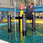 RIDING THE WAVE: Travis Tucker, an engineer at Electro Standards Laboratories, performs a preliminary in-water buoy testing for a project on wave-energy generation being done in collaboration with the University of Rhode Island. The test was done at the URI Bay Campus in Narragansett. / COURTESY ELECTRO STANDARDS LABORATORIES