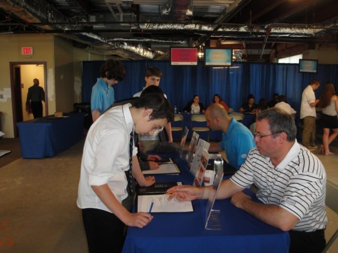 REVIEWING PART-TIME JOB OPTIONS with students at Vincent J. Gallagher Middle School, during the May 15 CU4 Reality Financial Education Fair, are Navigant Credit Union Vice President of Marketing Tim Draper and the credit union Marketing Manager Ross Silva.

 / COURTESY NAVIGANT