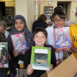 SIXTH GRADERS at Talbot Innovation Middle School in Fall River, Mass., hold books they received as part of a large book donation made by Ocean State Job Lot Charitable Foundation and Book Enterprises LLC. / COURTESY NEWBERRY PUBLIC RELATIONS & MARKETING