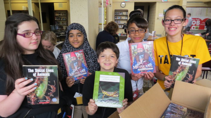 SIXTH GRADERS at Talbot Innovation Middle School in Fall River, Mass., hold books they received as part of a large book donation made by Ocean State Job Lot Charitable Foundation and Book Enterprises LLC. / COURTESY NEWBERRY PUBLIC RELATIONS & MARKETING