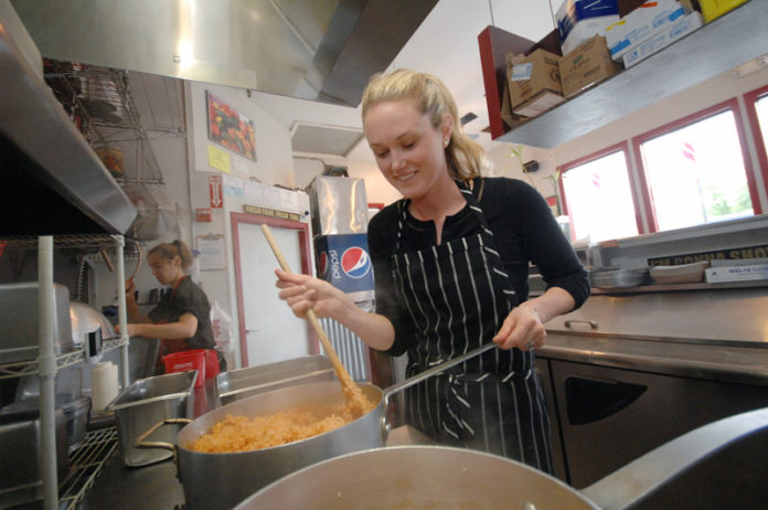 FULL PLATE: Jessica Silver Wood, co-owner of Fire & Water Restaurant Group, in the kitchen at Caliente Mexican Grill in the Kingston Emporium. / PBN PHOTO/BRIAN MCDONALD