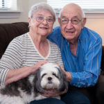 EXTENDED CARE: Pocasset Bay Retirement Community residents Marilyn and Richard Dutch with their 1-year-old Shitzu, Misty. The couple live in an independent-living apartment at Pocasset Bay. &ldquo;Seniors still need someone to care for and their pets are like family,&rdquo; said Karen Eller, administrator at Pocasset Bay. / PBN PHOTO/MICHAEL SALERNO