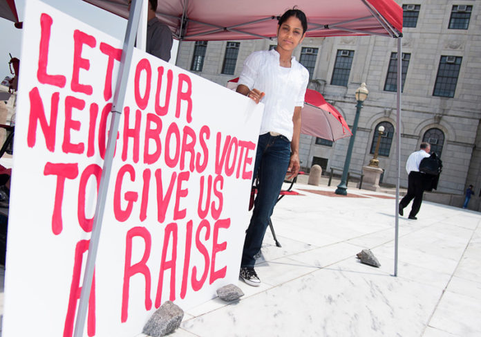 STOMACH PAINS: Renaissance Providence Hotel employee Santa Brito protests the denial of the $15 minimum wage for hotel workers during a Statehouse rally. / PBN PHOTO/MICHAEL SALERNO