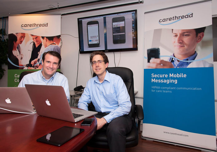 Providence-based Care Thread says it has a secure way for surgeons and nurses to coordinate patient care on their phones and through social media, instead of outdated pagers. “We are a secure social network, connecting the care team to each other, so they can … bring the patient into the conversation,” said company President Nick Adams, above left. The company has developed a mobile health-records app that can be used to immediately notify doctors when a patient is admitted or discharged. Also pictured is Chief Technology Officer Andrew Shearer. / PBN PHOTO/MICHAEL SALERNO