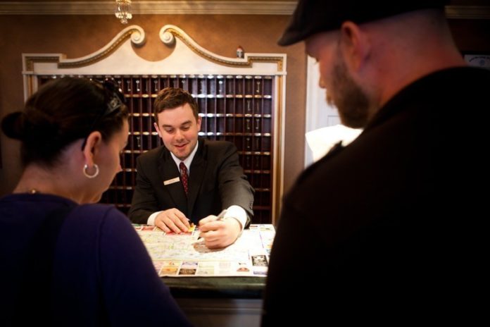 HOTELS IN PROVIDENCE, Warwick, Newport and Middletown reported strong activity during May, the first month of the tourist season. Above, front desk agent Gavin O'Brien shows Katrina and Sean Northrup of Washingtonville, N.Y., a map of downtown Newport as they check in to the Hotel Viking. / PBN FILE PHOTO/STEPHANIE ALVAREZ EWENS