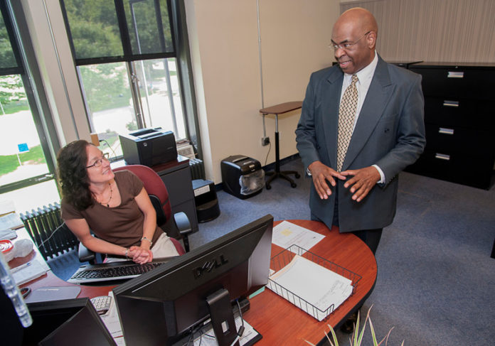 DEVELOPING STORY: Mark A. Stewart, the new state director of the R.I. Small Business Development Center at URI, speaks with executive assistant Patti Correia. / PBN PHOTO/ MICHAEL SALERNO