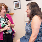 WELL OFF: Nurse practitioner Cathleen Jaderquist-Bassett, left, with patient Lorraine Robitaille at WellOne Primary Medical and Dental Care in Foster. Bassett said the Affordable Care Act is bringing in more insured patients. / PBN PHOTO/ MICHAEL SALERNO