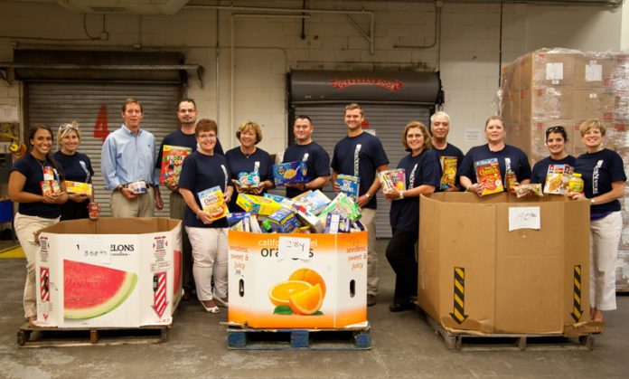 DOUG MAYHEW, president and CEO at OceanPoint Insurance Agency, third from left, along with BankNewport and OceanPoint Insurance employees, delivered more than 800 pounds of food to the Rhode Island Community Food Bank.