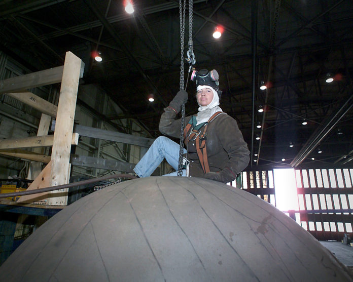 A RIGGER prepares to move a large component in the high bay shop at Electric Boat's Quonset submarine manufacturing facility. The company has added 720 new employees at its Quonset facility since the beginning of the year. / COURTESY ELECTRIC BOAT