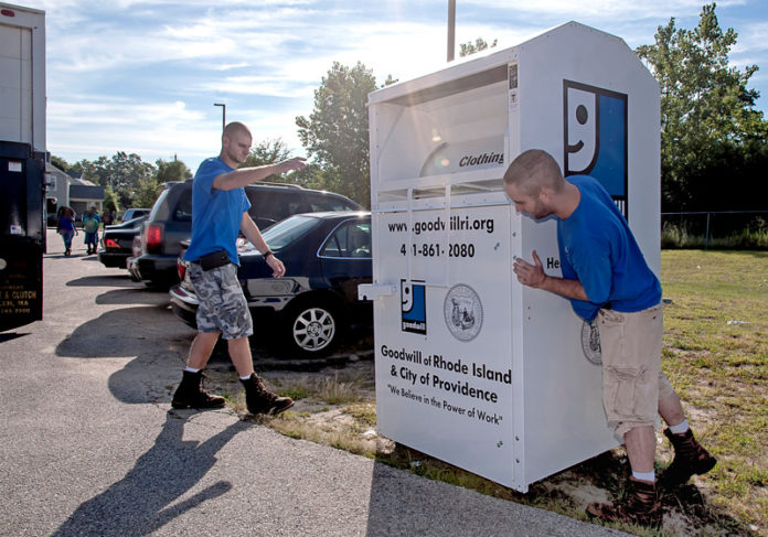 SECOND TIME AROUND: Tony Ottaviano, left, a driver for Goodwill Industries of Rhode Island, and Tom Keenan, assistant driver, placing a clothing recycling bin in Providence. / PBN PHOTO/ MICHAEL SALERNO