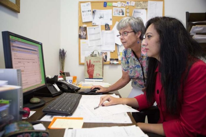 EXCHANGE OF IDEAS: Providence Center psychiatrist Ujala Fawad, above in red, sees promise in CurrentCare. Also pictured above is registered nurse Susan Hardy. / PBN PHOTO/RUPERT WHITELEY