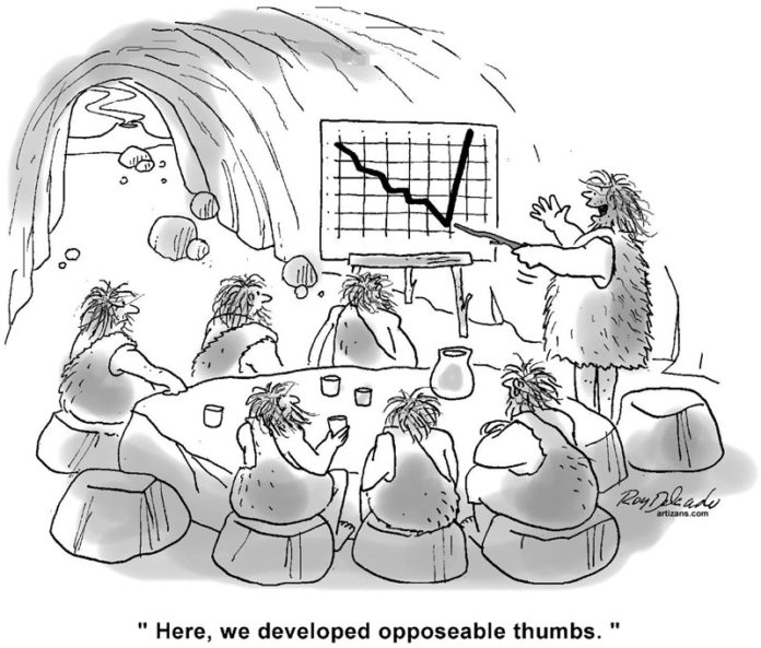 Cavemen, sitting on rocks, around a larger rock in a cave, listen to another caveman, who is leading the meeting say, “here is where we developed opposable thumbs,” while he points to a chart, with a stick, showing growth.
