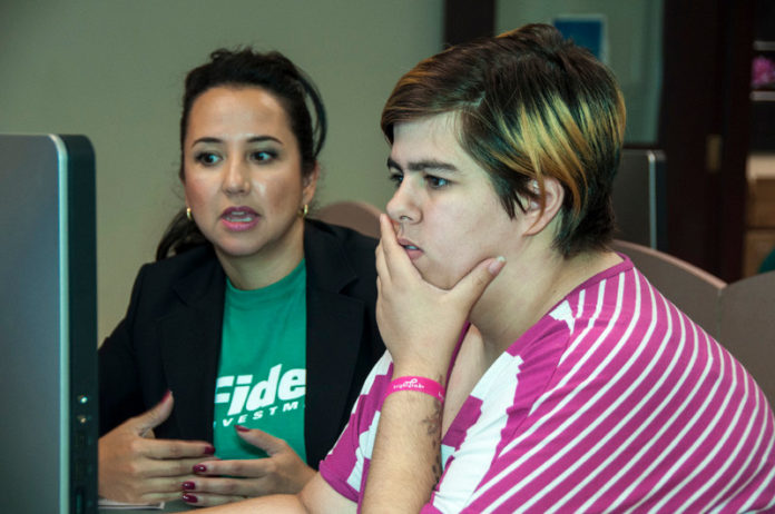 MARIA RUIZ, left, a Fidelity employee and chairwoman for the Aspire Employee Resources Group, worked with student Eva Kis during the “Invest in our Youth” workshops held over the summer.