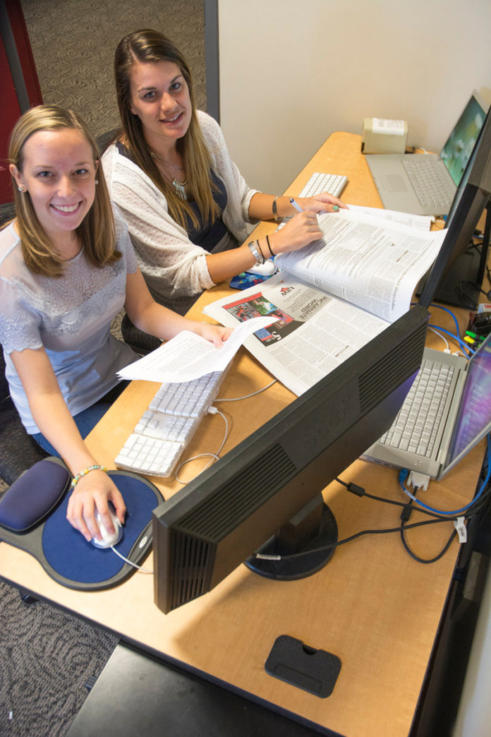 MAKING IT COUNT: URI undergraduate student Caitlin Musselman of New Hope, Pa., left, and URI graduate student Rachel Smith of Cranston, at work at the University of Rhode Island’s Department of Marketing and Communications. / COURTESY URI