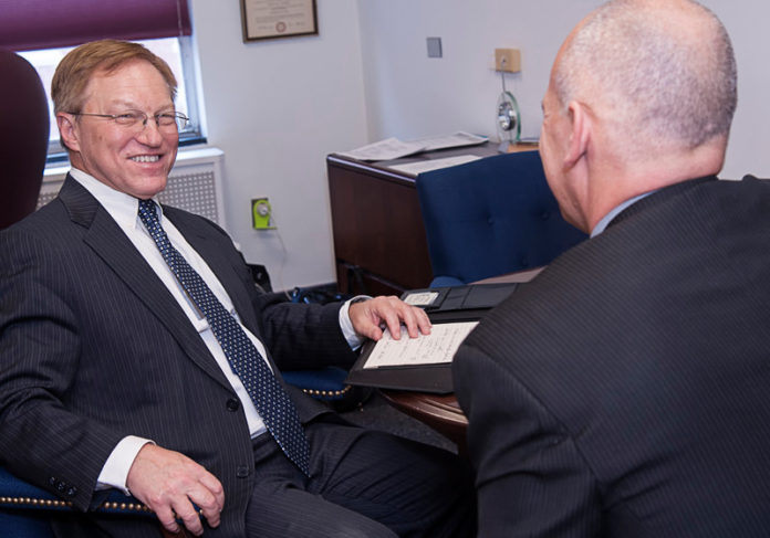 CHARTER MEMBER: Lester P. Schindel, left, CEO of CharterCARE Health Partners, speaks with communications officer Brett Davey. Schindel, who started in the role on Nov. 10, says his first tasks are getting to know the marketplace and gathering critical information. / PBN PHOTO/MICHAEL SALERNO
