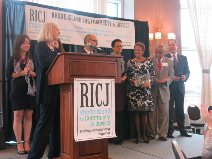 FROM LEFT: Bobby Rodriguez, Blue Cross & Blue Shield of Rhode Island; Jim Vincent, presenting the award, NAACP-Providence; Linda Newton, president and founder; Ramona Royal, Amica Insurance; Rafael Zapata, Providence College; Kelsey Dermody and Isobel Henao of Global View Communicatioins; Toby Ayers of RICJ, at podium.