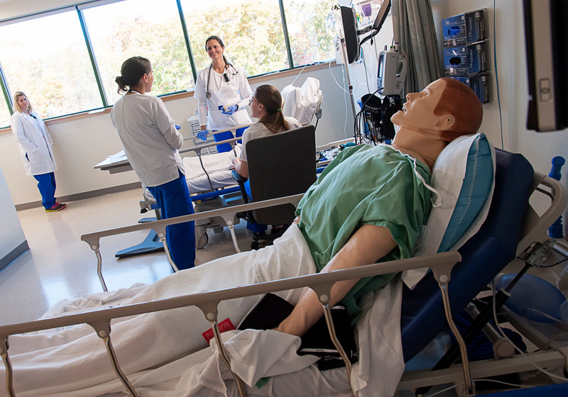 MED TECHS: Students in the nursing simulation lab at NEIT in East Greenwich. A hybrid progam allows students to get lab experience on campus and take other courses online. / PBN PHOTO/MICHAEL SALERNO