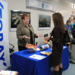 FEVER PITCH: Peg Lamere, Senior Recruiter with Toray Plastics (America) Inc., a tenant at Quonset Business Park, discusses job opportunities with Diane Miceli of North Kingstown. / COURTESY QUONSET DEVELOPMENT CORPORATION